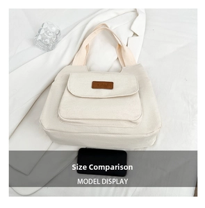 Detail of off-white canvas tote bag with fashion leather patch and large front pocket