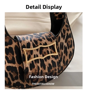 Detail of leopard print crescent bag with elegant wavy gold metal buckle and texture
