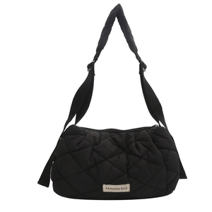 Minimalist black quilted tote bag with diamond stitching and adjustable shoulder strap