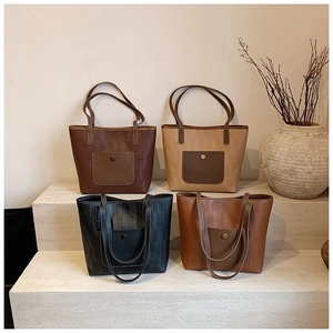Macro view of woven PU leather tote bags in four colors on a tiered stone display