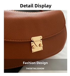 Close-up of brown litchi grain leather bag with a golden metal S-lock buckle detail