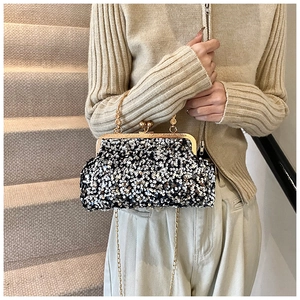 Détail d'un sac de soirée à paillettes avec fermoir métallique doré et bandoulière