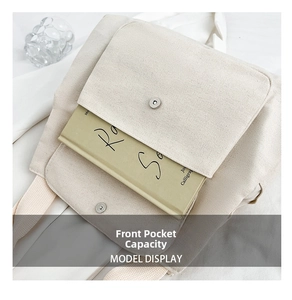 Detail of canvas tote bag front pocket with silver magnetic buckle and ivory texture