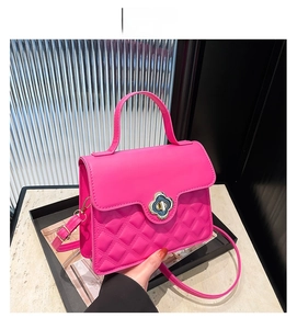 Detail of rose red quilted crossbody bag with golden flower clasp and matte PU leather