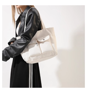 Detail view of large cream canvas tote bag with functional zipper and snap pocket detail