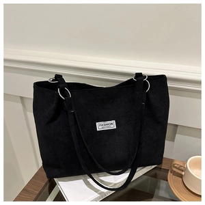 Detail of corduroy tote bag with Fashion Instinct label and silver metal strap rings