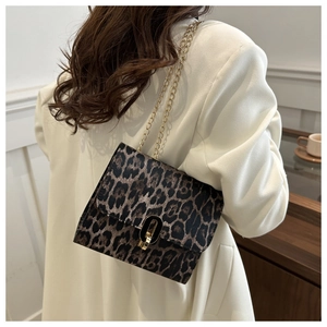 Close-up of leopard print crossbody bag featuring gold chain and oval metal buckle