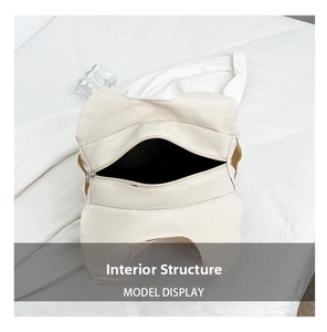 Internal structure of off-white canvas tote bag showing the zipper and spacious compartment