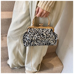 Gros plan d'un sac de soirée à paillettes avec fermoir doré et bandoulière chaîne