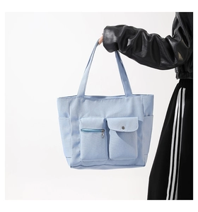 Detail view of large nylon tote bag featuring front zip pocket and sturdy side pockets