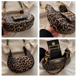 Detail view of leopard print crescent bag with gold hardware and internal storage