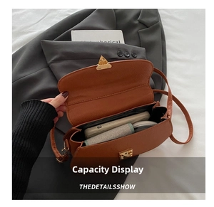 Interior capacity detail of brown pebble leather crossbody bag with gold buckle