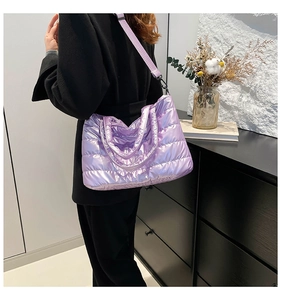 Close-up of quilted lavender metallic puffer tote bag showing glossy texture and padded strap