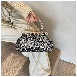 Détail du sac à paillettes noir avec cadre métallique doré et poignée fleurie élégante