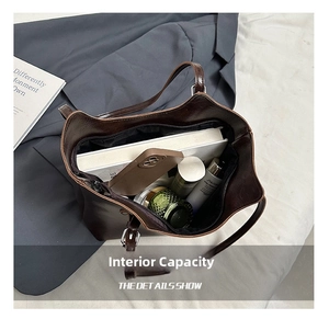 Macro view of the spacious inner compartment of a vintage dark brown leather tote bag