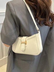 White minimalist PU leather shoulder bag with gold clasp shown on a grey blazer outfit