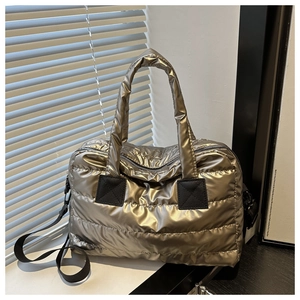 Close-up of metallic quilted boston bag featuring puffer fabric and natural light texture