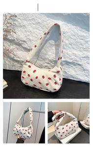 Detail of white corduroy shoulder bag with strawberry print and sturdy zipper closure