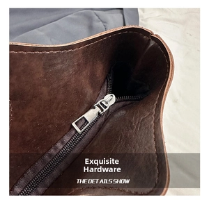 Close-up of premium silver metal zipper and brown leather texture on a tote bag