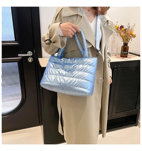 Detail of light blue quilted tote bag with metallic finish and adjustable shoulder strap
