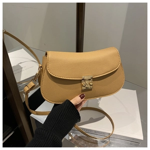 Detail of camel lychee grain leather crossbody bag featuring gold geometric metal clasp