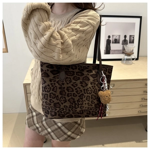 Détail du sac cabas léopard avec bandoulière marron et petit pendentif ours en peluche