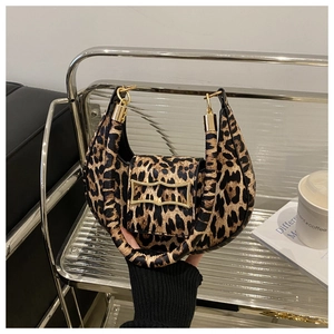 Detail of trendy leopard print underarm bag with gold irregular metal clasp and curved design
