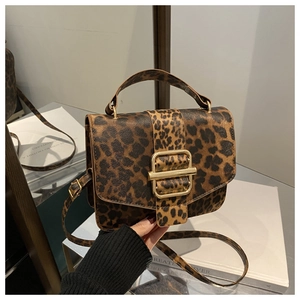 Détail du sac à main vintage léopard avec boucle carrée dorée et bandoulière texturée assortie