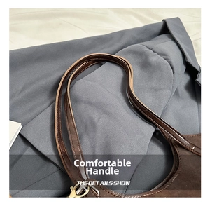 Detail of dark brown leather handle with cream stitching and gold metal hardware