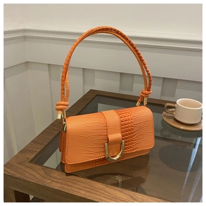 Detail of orange stone-textured bag showing faux-crocodile leather and golden U-lock