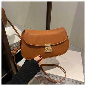 Detailed view of caramel lychee texture leather handbag with golden metal buckle clasp