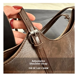 Detail of adjustable shoulder strap with metal buckle on retro brown tote bag