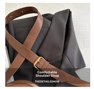 Détail de la bandoulière en cuir marron avec une boucle carrée en métal doré