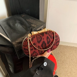 Dettaglio pochette leopardata rossa con chiusura a fiocco dorato e tracolla a catena