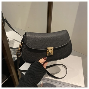 Close-up of black lychee grain leather crossbody bag with elegant gold metal buckle clasp
