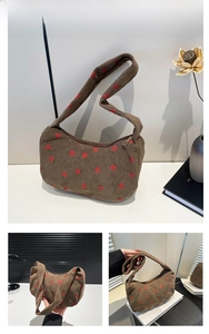 Close-up of brown corduroy shoulder bag with strawberry print and wide strap detail