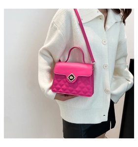 Detail of rose pink crossbody bag featuring quilted faux leather and gold floral lock