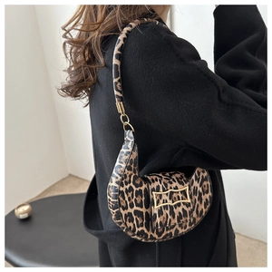 Chic leopard print saddle bag with gold buckle on black coat for a trendy look