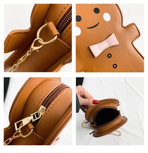 Detail view of gingerbread man crossbody bag with embroidery, zipper and gold chain