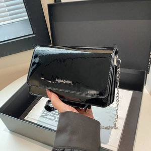 Glossy black patent leather shoulder bag with silver chain strap and minimalist text