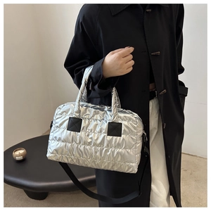 Detail der silbernen Stepptasche mit Metallic-Finish und verstellbarem schwarzem Gurt