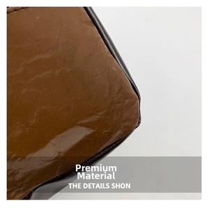 Close-up detail of glossy brown leather material with smooth texture and fine stitching