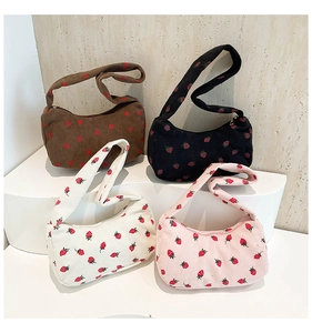 Group display of corduroy shoulder bags with strawberry embroidery in four colors