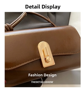 Detailed close-up of a vintage brown oil wax leather square bag with gold metal clasp