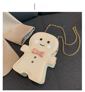 Detail of gingerbread man shoulder bag in cream white with a gold chain strap