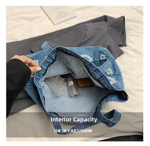 Detailed interior of denim tote bag showing spacious capacity and secure zipper closure