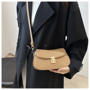 Close-up of khaki lychee grain leather crossbody bag with a gold metal clasp buckle