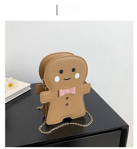 Detail of khaki gingerbread man crossbody bag with pink bow and gold chain strap