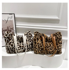 Detail view of plush leopard print tote bags in two colors on a modern white stand