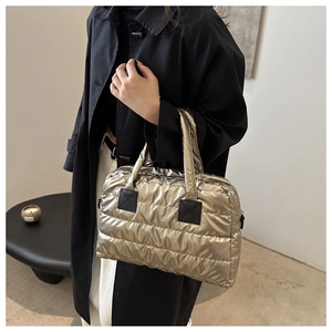 Detail view of gold quilted puffer bag showing the metallic nylon texture and stitching